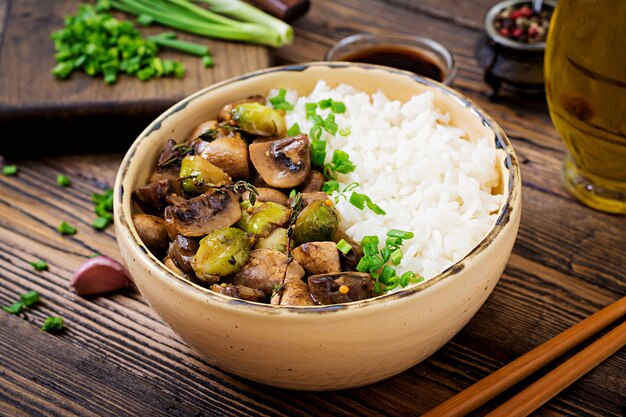 Menu vegano Cibo dietetico Riso bollito con funghi e cavoletti di Bruxelles in stile asiatico.