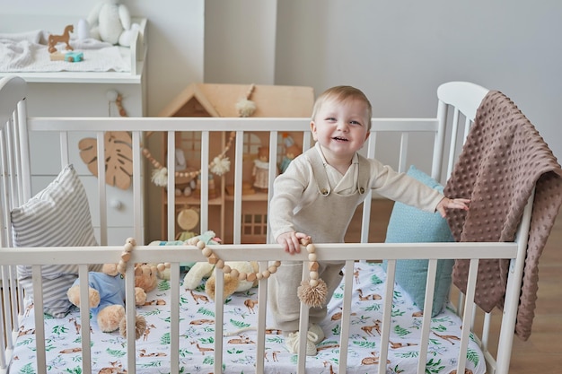 Meraviglioso bambino con gli occhi azzurri nella culla Bambino che gioca con i giocattoli nella scuola materna Asilo infantile dello sviluppo iniziale Sala giochi Festa dei bambini Festa della mamma