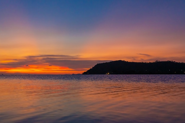 Meraviglioso paesaggio al tramonto in riva al mare, colori del cielo al tramonto e silhouette dell'isola nell'acqua. incredibile tramonto tropicale