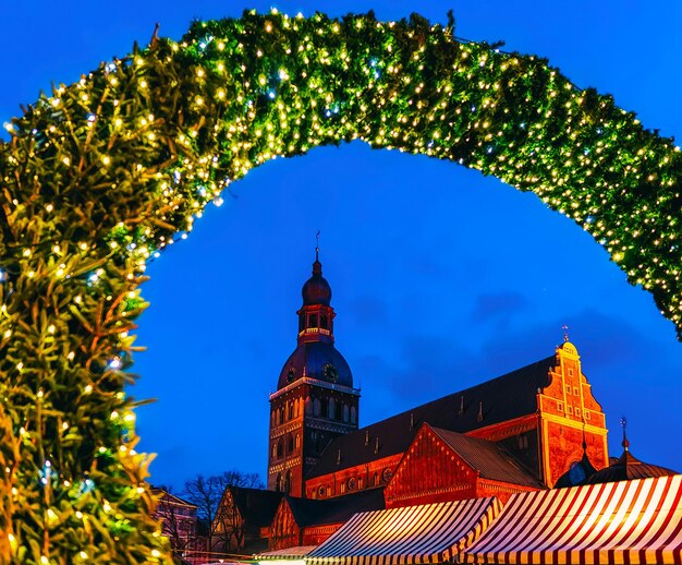 Mercatino di Natale di Piazza Duomo con albero di Natale e bancarelle a Riga in Lettonia inverno. A tarda sera. Fiera di strada e di festa nella città europea Decorazione dell'Avvento con oggetti di artigianato su Bazaar