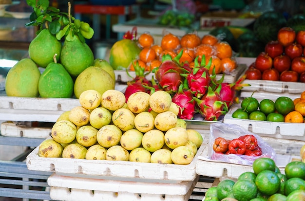 Mercato asiatico degli agricoltori di strada che vende frutta fresca a Hoi An, Vietnam. Mango, guava e frutto del drago. Colori giallo, rosso e verde.