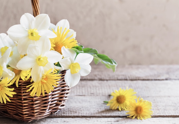 Merce nel carrello dei fiori della primavera su fondo di legno