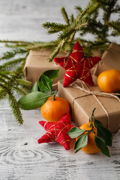 Merce nel carrello della composizione in Natale con i mandarini e l'albero di abete