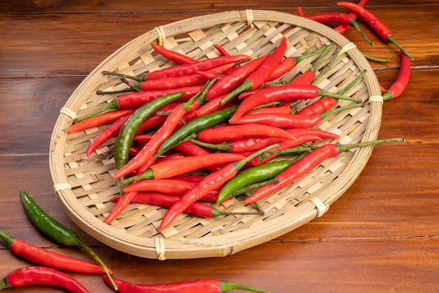 Merce nel carrello di peperoncino rosso e verde su fondo di legno