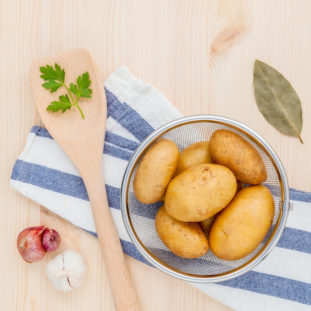 Merce nel carrello organica fresca delle patate con le erbe sulla tavola di legno.