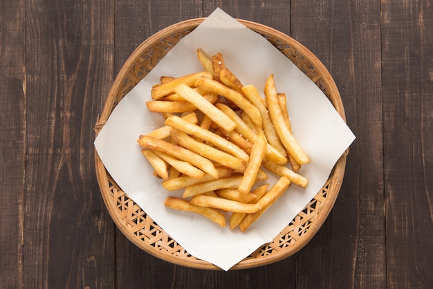 Merce nel carrello tradizionale delle patate fritte su fondo di legno