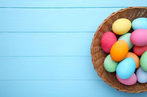 Merce nel carrello variopinta delle uova di Pasqua sull'azzurro