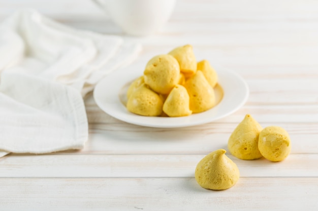 Meringa alla banana in un piatto bianco e una tazza di tè su uno sfondo chiaro. Senza zucchero