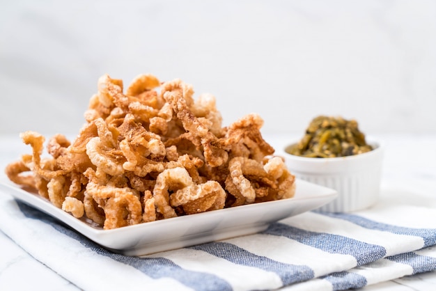 Merluzzo di maiale fritto o spuntino di maiale con salsa di peperoncino verde verde del Nord