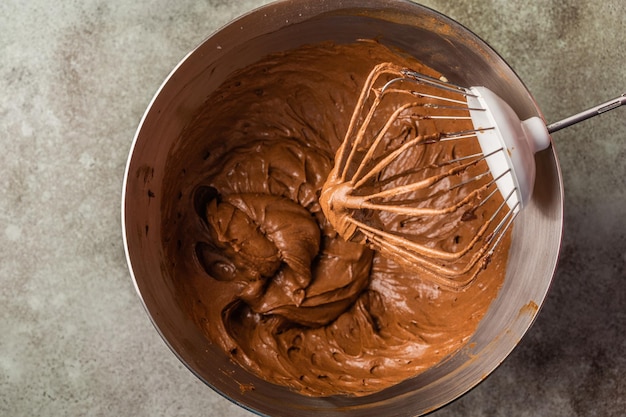 Mescolando l'impasto dei brownies della torta al cioccolato in una ciotola vista dall'alto da vicino