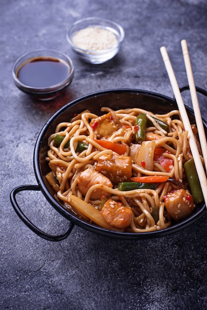 Mescolare gli spaghetti con pollo, tofu e verdura.