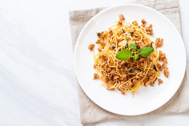 mescolare gli spaghetti fritti con carne di maiale e basilico tritati