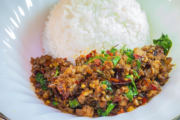 Mescolare il basilico fritto con carne di maiale tritata su riso