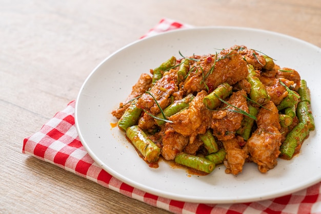 Mescolare il maiale fritto e la pasta di curry rosso con i fagioli