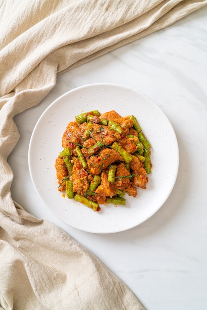 Mescolare il maiale fritto e la pasta di curry rosso con i fagioli