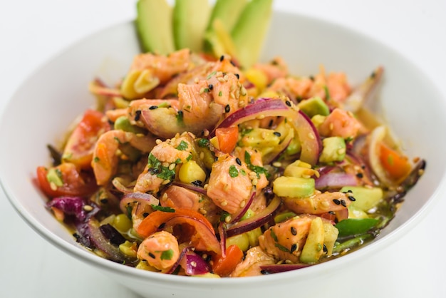 Mescolare l&#39;insalata giapponese con salmone, pomodoro, avocado e cipolla.