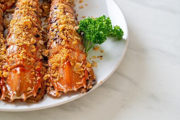 Mescolare le cicale di mare fritte con aglio sulla piastra bianca