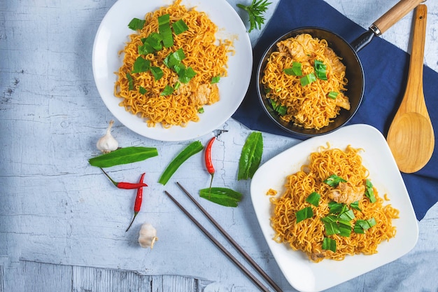 Mescolare tagliatelle con verdure in un piatto bianco su un pavimento di legno.