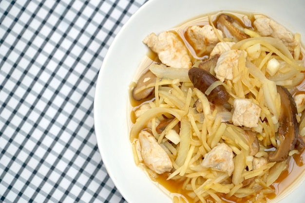 Mescoli il pollo fritto con lo zenzero, la cipolla, il fungo di shiitake e l&#39;aglio piccanti sul piatto bianco.