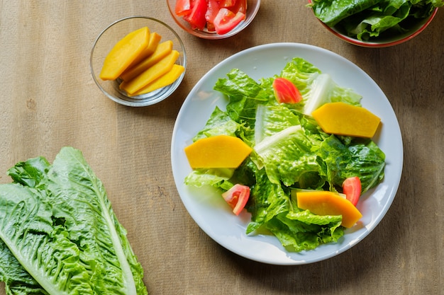 Mescoli la verdura di insalata in piatto bianco, vegano