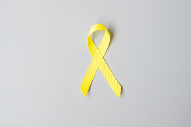 Mese di sensibilizzazione sul cancro infantile, sarcoma, ossa, vescica e prevenzione del suicidio, nastro giallo oro per sostenere le persone che vivono e le malattie. bambini Concetto di assistenza sanitaria e giornata mondiale del cancro