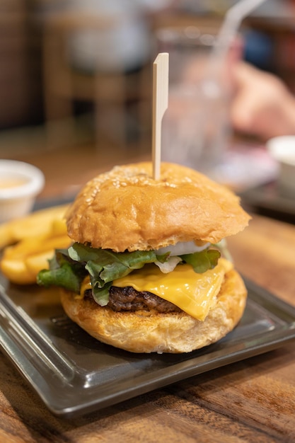 messa a fuoco selettiva delizioso hamburger fatto in casa di formaggio di manzo e verdure su un vecchio tavolo di legno