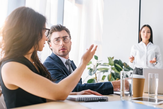 Messa a fuoco selettiva dell'uomo d'affari multirazziale e delle donne d'affari che lavorano insieme su un progetto di business in