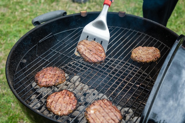 Messa a fuoco selettiva di deliziose cotolette di hamburger alla griglia sulla griglia per barbecue