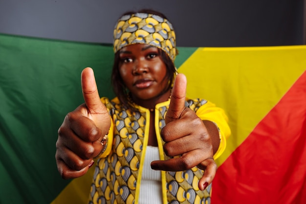 Messa a fuoco selettiva felice giovane donna africana sorridente con la bandiera della repubblica del congo sullo sfondo