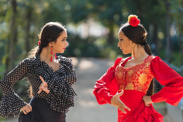 Messa a fuoco selettiva in due donne in abito da flamenco che ballano in un parco