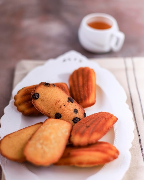 Messa a fuoco selezionata Bella biscotti Shell Madeleine Primo piano sul tavolo, Madeleine con gocce di cioccolato