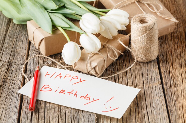 Messaggio di buon compleanno con fiori sul tavolo rustico con fiori