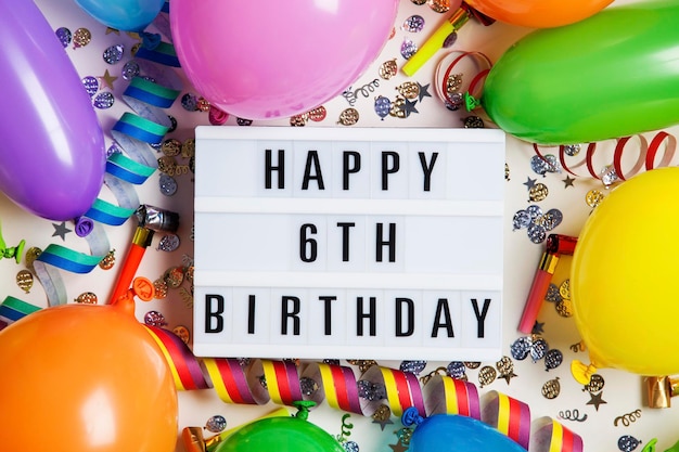 Messaggio di celebrazione del sesto compleanno felice su una scatola luminosa con palloncini e coriandoli