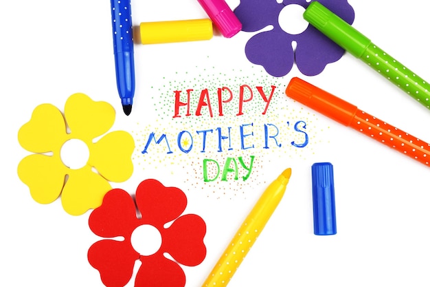 Messaggio di Happy Mothers Day scritto su carta con pennarelli e fiori decorativi da vicino