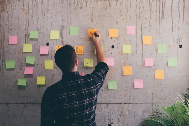 Messaggio di scrittura dell&#39;uomo di affari sul post-it.