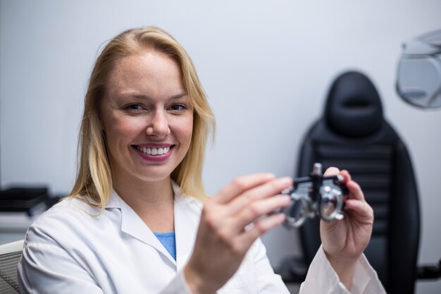 Messbrille femminile sorridente della tenuta dell'optometrista