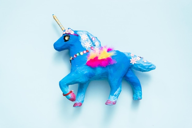 Mestiere per bambini. Dipinto di blu e decorato con gioielli e piume in cartapesta unicorno.