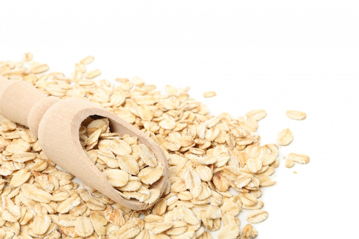 Foto mestolo con fiocchi d'avena isolati sul muro bianco