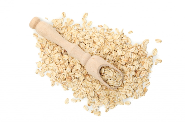Foto mestolo con fiocchi d'avena isolati sul muro bianco