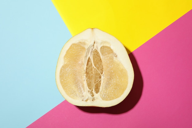 Metà del frutto maturo del pomelo su tre toni