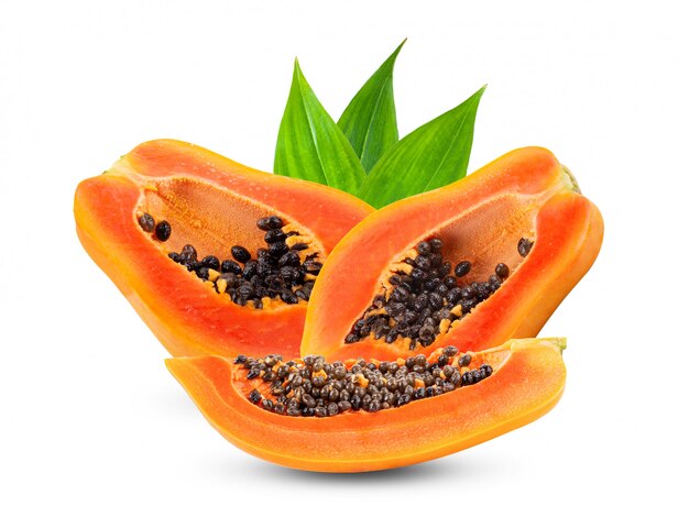 Metà della frutta matura della papaia con i semi sulla parete bianca.