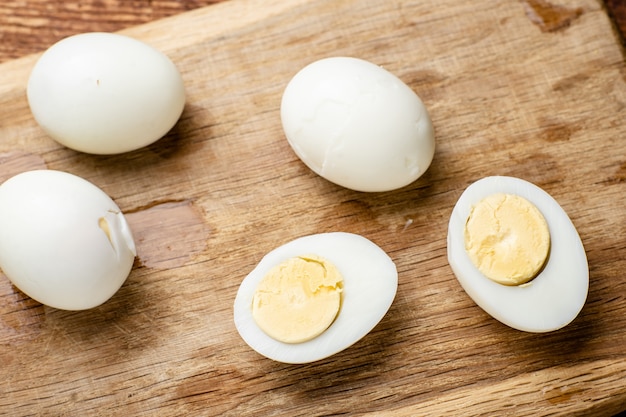 Metà delle uova di gallina bollite su uno sfondo di legno.