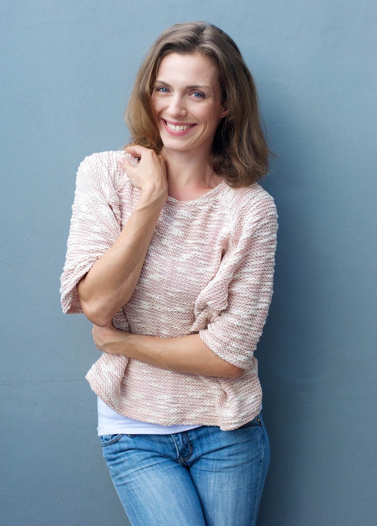 Foto metà di donna adulta allegra che sorride in jeans e maglione
