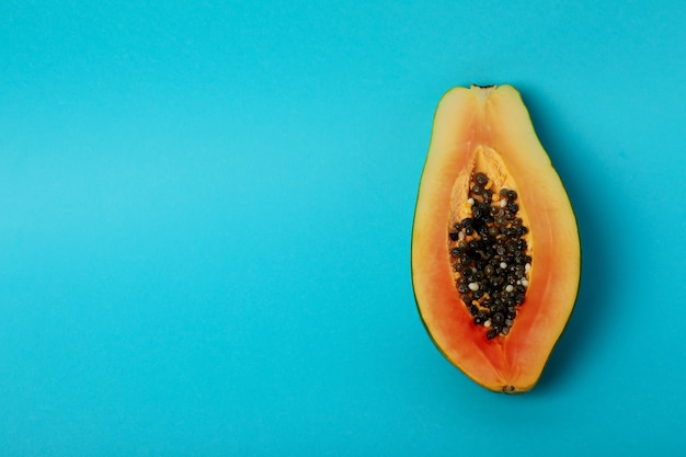 Metà di papaia matura su sfondo blu