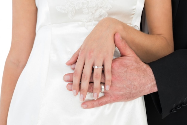 Metà di sezione della sposa e dello sposo che indossa fede nuziale