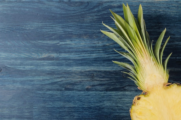 Metà fresche dell'ananas maturo su fondo di legno blu estate frutta vista dall'alto spazio per il testo