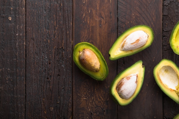 Metà organiche fresche dell'avocado sulla vecchia tavola di legno