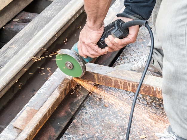 Metallo di taglio uomo meccanico con scintilla grinder