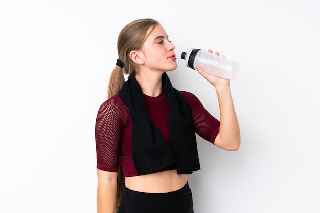 Metta in mostra la ragazza dell'adolescente sopra bianco con la bottiglia di acqua di sport