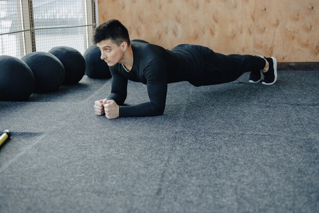 Mette in mostra il ragazzo che fa l'esercizio della plancia. palestra e sport. uno stile di vita sano.